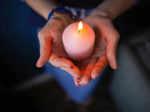 Closeup childrens hands hold a candle in the church during prayer. — Stockfoto