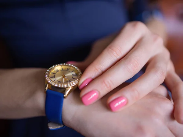 Close up detalhes da moda, jovem mulher de negócios segurando seu relógio de ouro. classificado em cores quentes . — Fotografia de Stock
