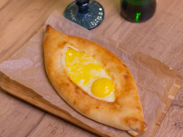 Fresh delicious Adjarian khachapuri with microgreens served on wooden table. — Stock Photo, Image