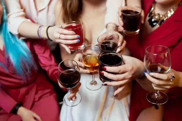 Празднование со стаканами алкоголя в руках. Счастливые подруги, хорошо проводящие время. — стоковое фото