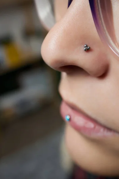Nahaufnahme einer jungen Frau mit durchdringendem Septum, das an ihrer Nase hängt. — Stockfoto