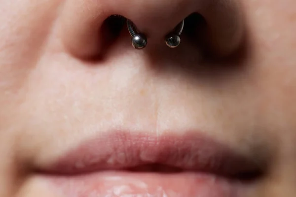 Närbild av en ung kvinna ansikte med piercing septum hängande från näsan. — Stockfoto