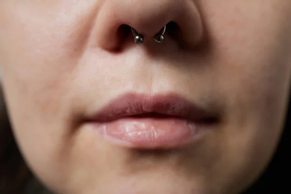 Närbild av en ung kvinna ansikte med piercing septum hängande från näsan. — Stockfoto