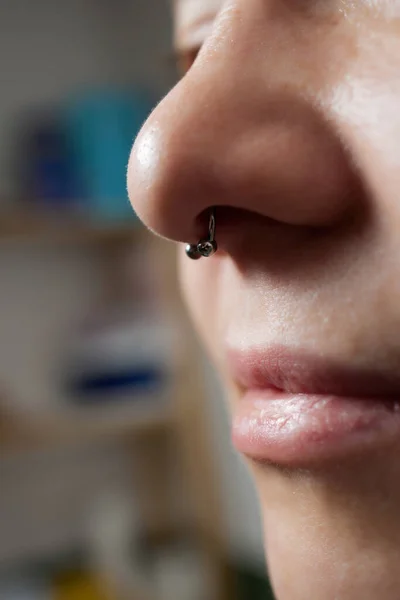 Närbild av en ung kvinna ansikte med piercing septum hängande från näsan. — Stockfoto