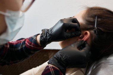 Kulağında piercing var. Şeytanminaresi ve sarmal piercingler.