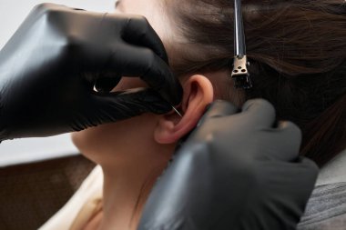 Kulağında piercing var. Şeytanminaresi ve sarmal piercingler.
