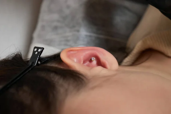 Piercings em uma orelha. Concha e piercings hélice de perto. — Fotografia de Stock