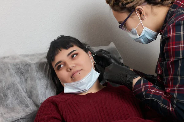 Professional holding the jewel of piercing day just before screw the ball. Tragus type. — Stock Photo, Image