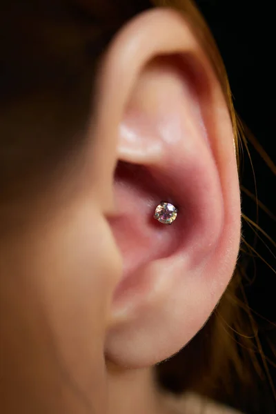 Piercingar på örat. Conch och helix piercings närbild. — Stockfoto