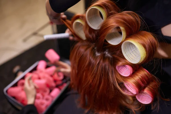 Gros plan de cheveux roux lors de la coiffure avec curler. — Photo