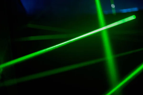 밝은 녹색 네온 레이저빛은 공상 과학 효과로 선 과 삼각형 모양을 만드는 어둠을 밝게 비추고 있다.. — 스톡 사진