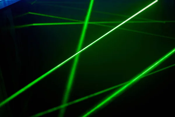 Яскраво-зелені неонові лазерні ліхтарі освітлюють темряву створюючи лінії і форми трикутника в науково-фантастичному ефекті . — стокове фото