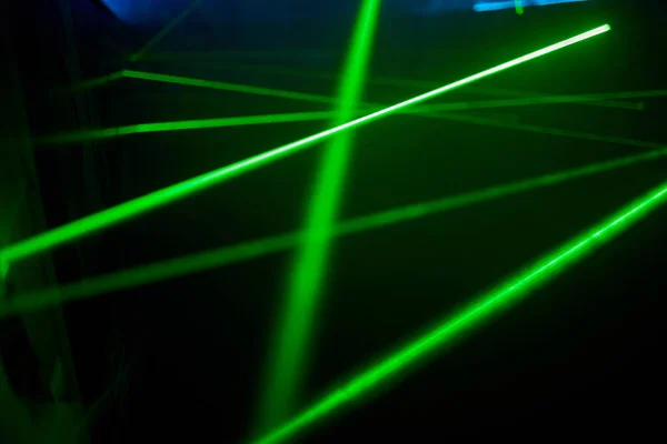 Ярко-зеленые неоновые лазерные огни освещают темноту, создавая линии и треугольные формы в научно-фантастическом эффекте.. — стоковое фото