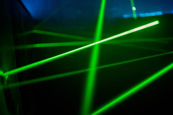 Bright green neon laser lights illuminate the darkness creating lines and triangle shapes in sci-fi effect. — Stock Photo, Image