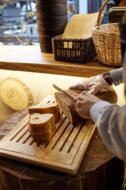 Ahşap masa, seçici odak üzerinde kesme buğday ekmek erkek eller.