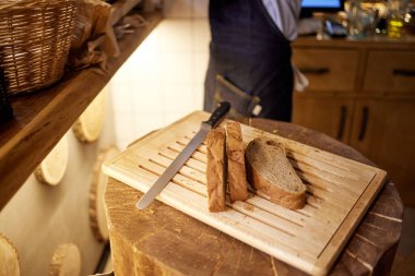 Ahşap masa, seçici odak üzerinde kesme buğday ekmek erkek eller.