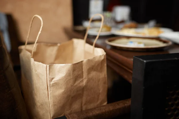 Dessertpapieren zak voor de klant klaar op de toonbank in moderne cafe coffeeshop, levering van voedsel, cafe restaurant, afhaalmaaltijden. — Stockfoto