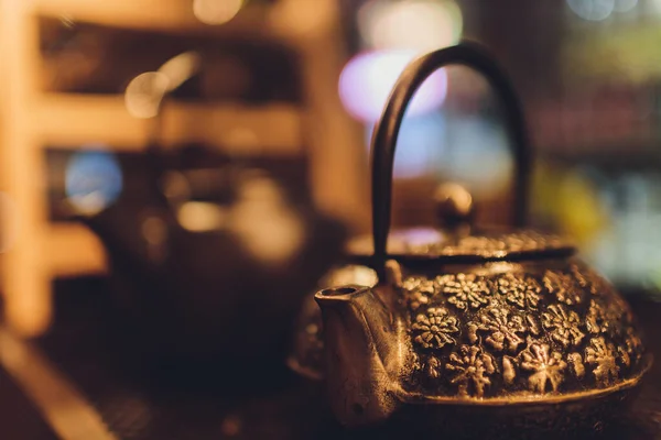 Cast iron black kettle on the table on a brown background. Tea ceremony. — Stock Photo, Image