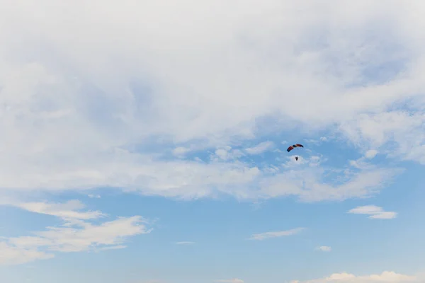 A gliding parachutist with a parachute color of Russian flag against blue sky. — Stock Photo, Image