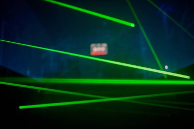 Parlak yeşil neon lazer ışıkları karanlığı aydınlatır. Bilim kurgu efektiyle çizgiler ve üçgen şekiller yaratır..