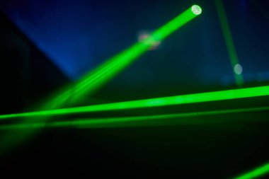 Parlak yeşil neon lazer ışıkları karanlığı aydınlatır. Bilim kurgu efektiyle çizgiler ve üçgen şekiller yaratır..