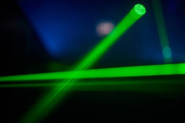 Parlak yeşil neon lazer ışıkları karanlığı aydınlatır. Bilim kurgu efektiyle çizgiler ve üçgen şekiller yaratır..