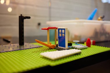 Renkli bir inşaat seti, bir evin zemininde, yakın plan. Çocuklar için eğitici oyunlar. Plastik çocuk tasarım küpleri, seçici odaklanma .