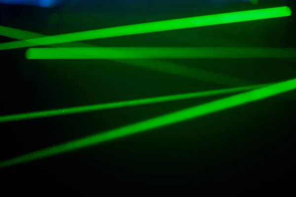 Ярко-зеленые неоновые лазерные огни освещают темноту, создавая линии и треугольные формы в научно-фантастическом эффекте.. — стоковое фото