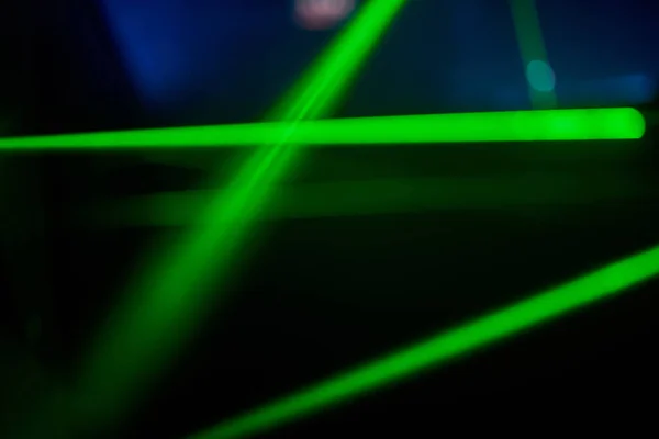 Luzes de laser de néon verde brilhante iluminam a escuridão criando linhas e formas de triângulo no efeito sci-fi. — Fotografia de Stock
