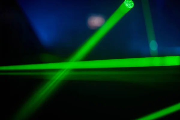 Parlak yeşil neon lazer ışıkları karanlığı aydınlatır. Bilim kurgu efektiyle çizgiler ve üçgen şekiller yaratır.. — Stok fotoğraf