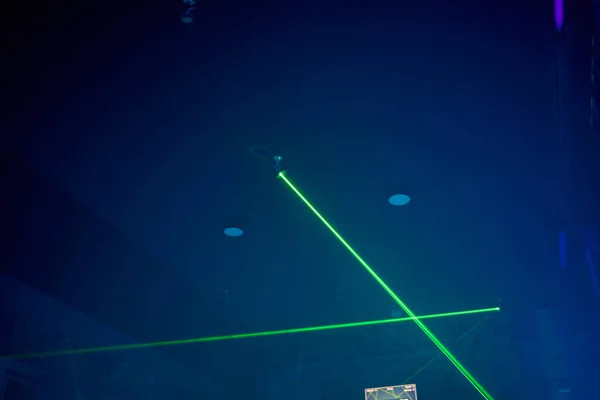 Heldere groene neon-laserlichten verlichten de duisternis en creëren lijnen en driehoekvormen in sci-fi-effect. — Stockfoto