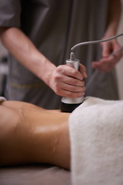 Kadın karın bölgesindeki selüliti, karın masajını kaldırma prosedürü. Kilo vermek için ultrasonik masaj. Cerrahi müdahale olmadan kadın figürünün düzeltilmesi. Karnına yakın çekim..