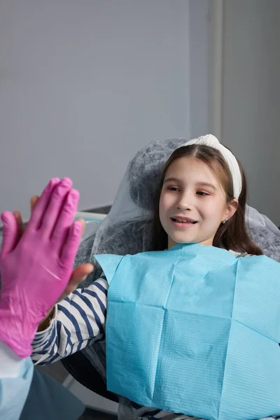 Nettes kleines Mädchen sitzt auf Zahnarztstuhl und hat Zahnbehandlung. — Stockfoto