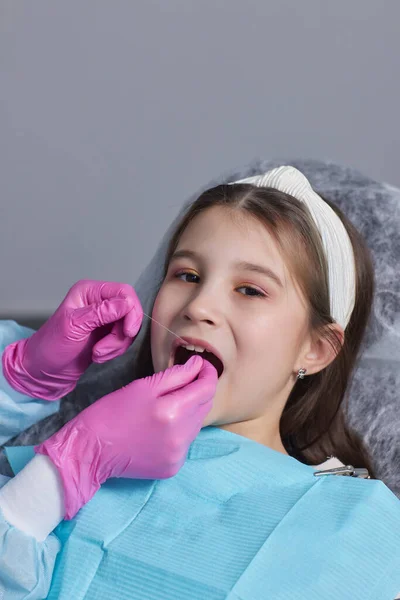Tagli mani di vista in guanti di lattice per filare denti anteriori di bambino. Donna tenere strumenti dentali accanto . — Foto Stock