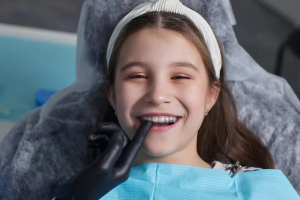 Caucasica bambina allineatore invisibile e indicando i suoi perfetti denti dritti. Sanità dentale e concetto di fiducia. — Foto Stock