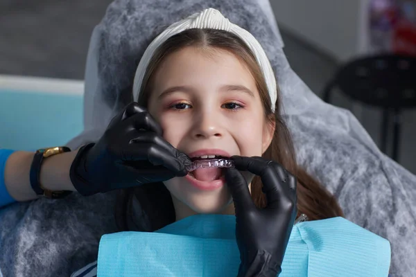 Caucasica bambina allineatore invisibile e indicando i suoi perfetti denti dritti. Sanità dentale e concetto di fiducia. — Foto Stock