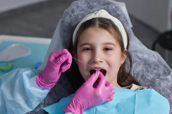 Tagli mani di vista in guanti di lattice per filare denti anteriori di bambino. Donna tenere strumenti dentali accanto . — Foto Stock
