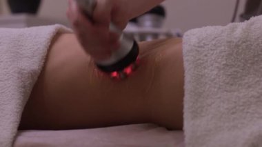 Kadın karın bölgesindeki selüliti, karın masajını kaldırma prosedürü. Kilo vermek için ultrasonik masaj. Cerrahi müdahale olmadan kadın figürünün düzeltilmesi. Karnına yakın çekim..