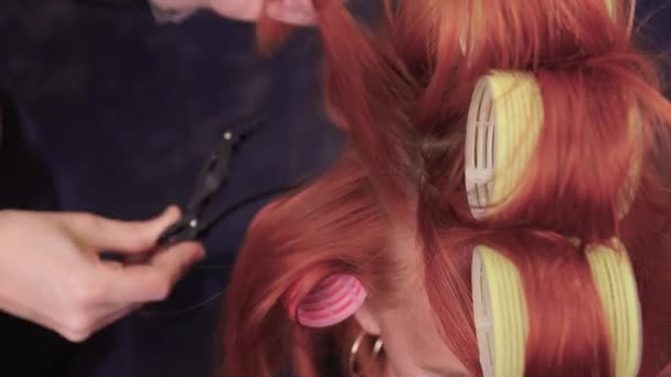 Sluiten van rood haar tijdens het haar dressing met krulspelden. — Stockvideo