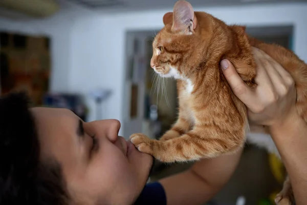 Young man in t shirt holding a cat. — Stock Photo, Image