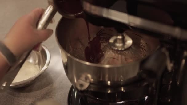 Primer plano de las manos femeninas mezclando masa y salsa de chocolate con una batidora eléctrica. — Vídeo de stock