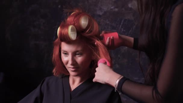 Gros plan de cheveux roux lors de la coiffure avec curler. — Video