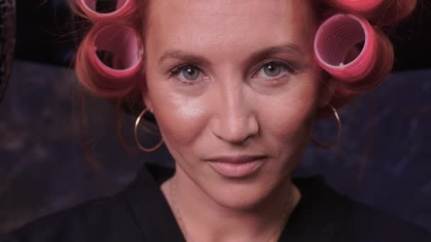 Närbild av rött hår under hårbehandling med locktång. — Stockvideo