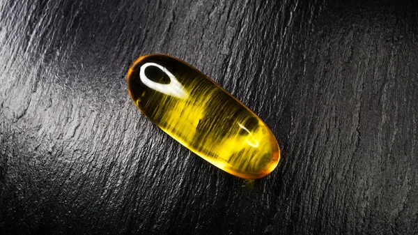 Sıvı ilaç içeren açık sarı kapsül, nesne fotoğrafı makro fotoğraf