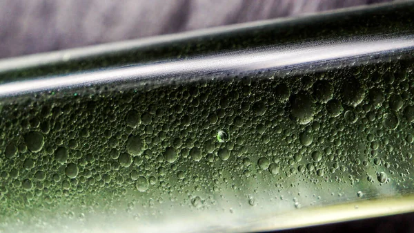 Yeşil kimyasal sıvıyla dolu pipette cam tüp, makro fotoğraf objesi.