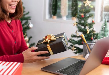 İş kadını Noel 'de hediye kutusunu ofis masasında tutuyor.. 