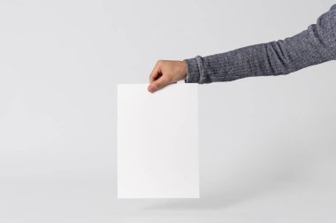 boş kağıt A4 afiş gri arka plan üzerinde marka mockup şablonu logo için gösterilen El.