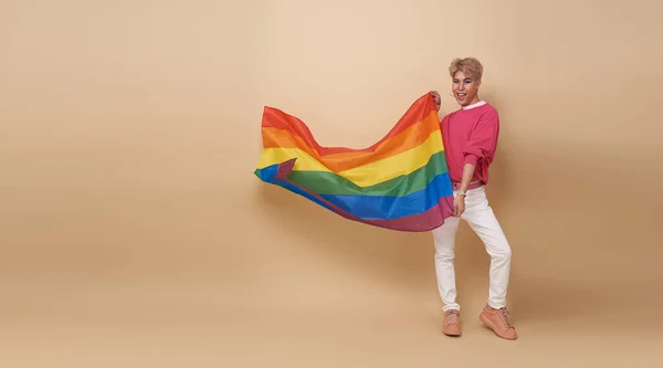若いアジア系トランスジェンダーのLgbtとレインボーフラッグがヌードの背景に隔離されている ゲイのプライドフラグの概念を持つ男 — ストック写真