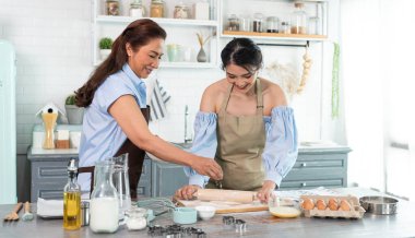 Mutlu Asyalı aile evde hamur yoğurup kurabiye pişiriyor. Aile aktivitelerinin tadını çıkarın..