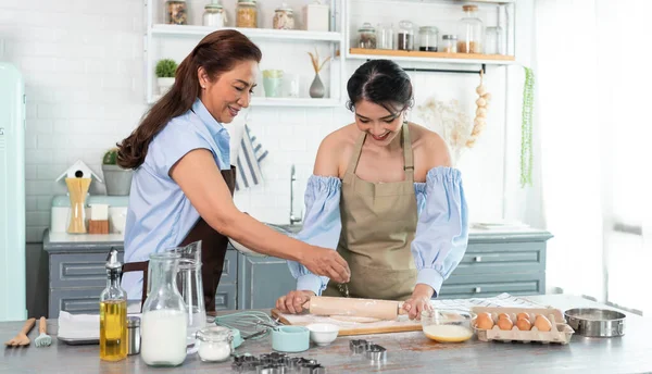 Mutlu Asyalı aile evde hamur yoğurup kurabiye pişiriyor. Aile aktivitelerinin tadını çıkarın..